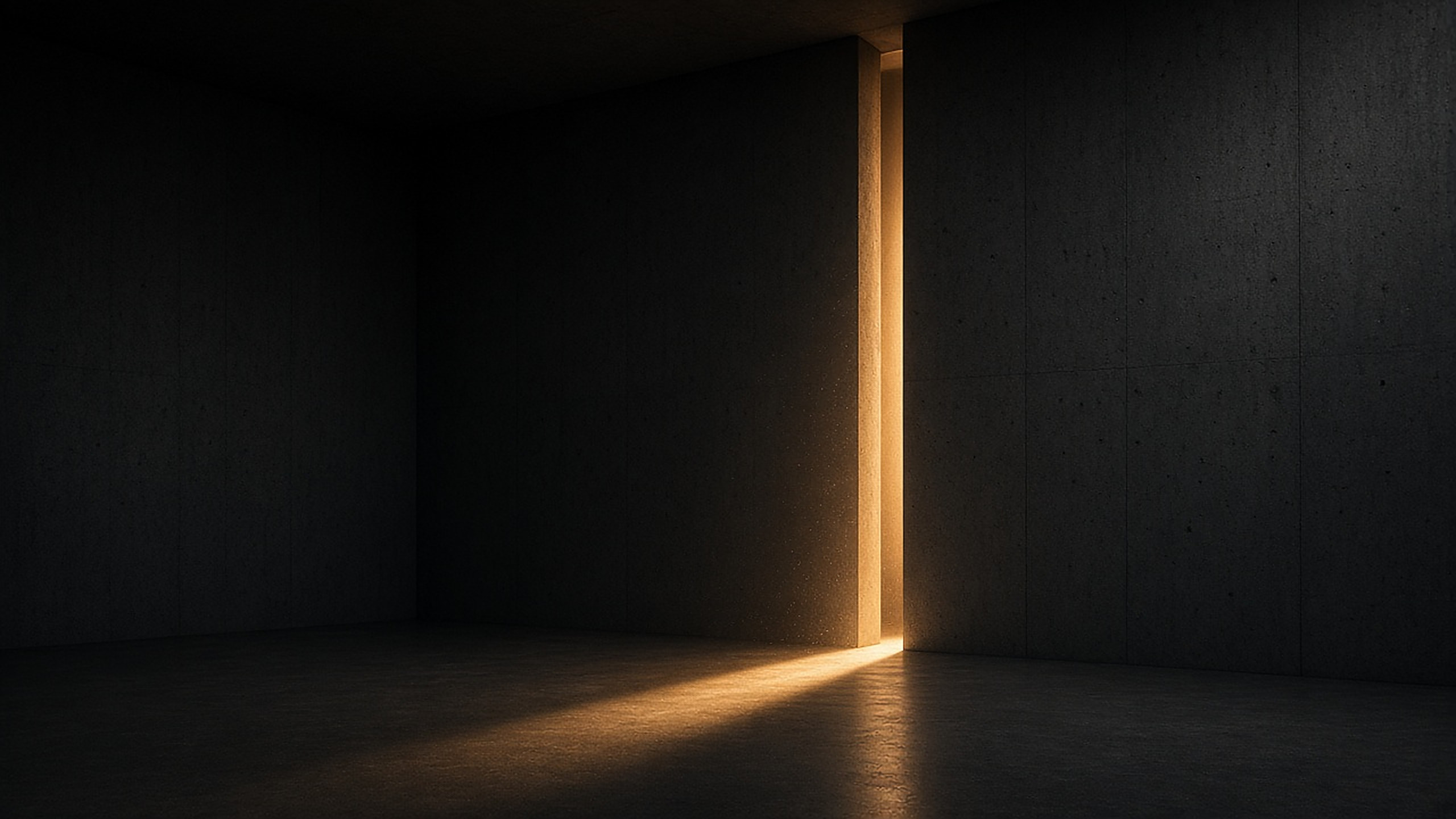 A seam of warm light opening into a dark concrete room